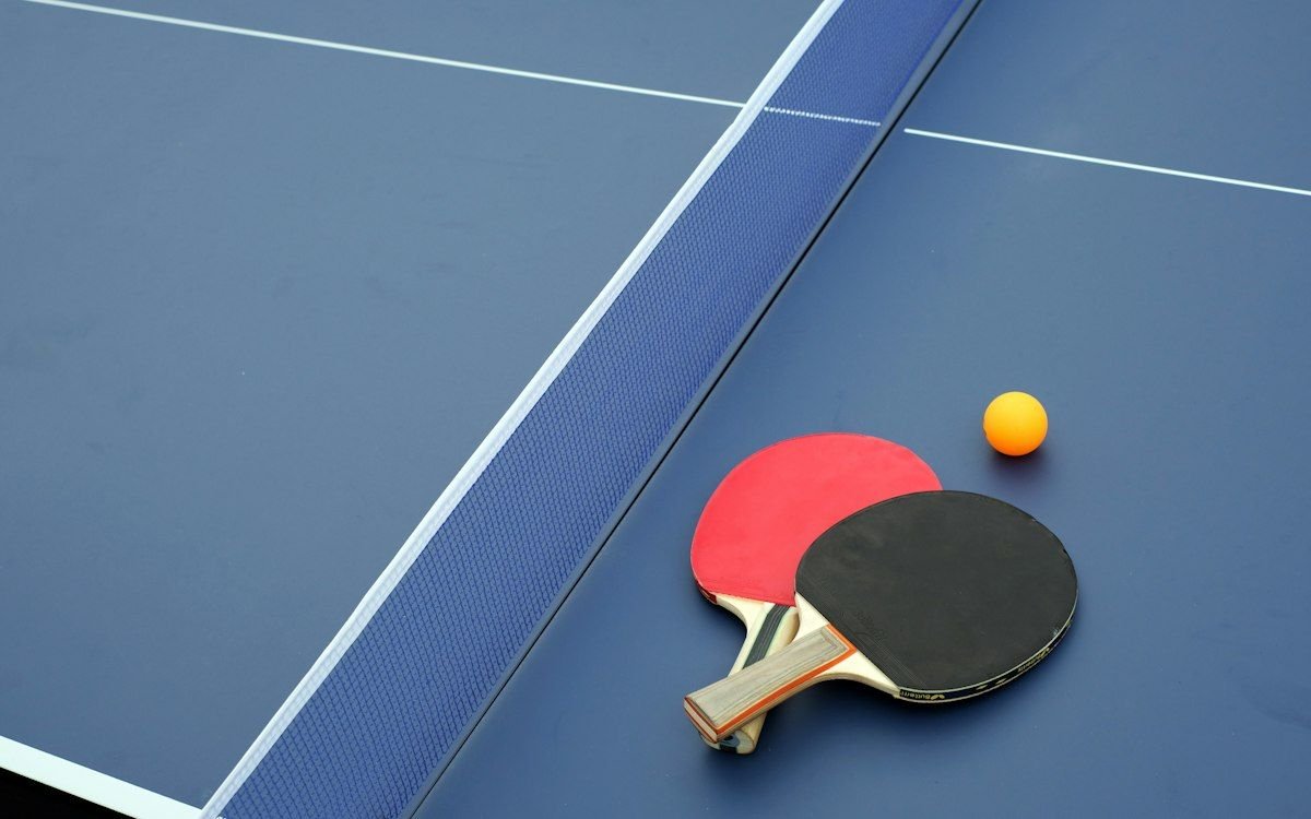 Raquetas y pelota sobre una mesa de tenis de mesa